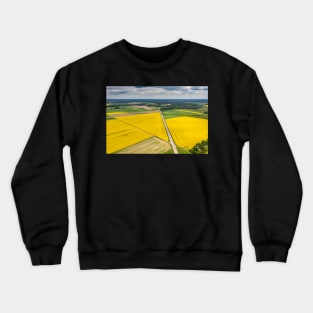 Agricultural landscape, fields of yellow colza and green grain under moody cloudy Crewneck Sweatshirt